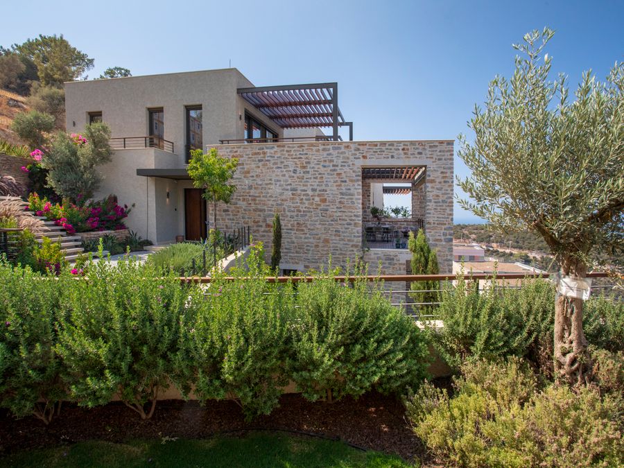 Vivienda unifamiliar de nueva planta con fachada de piedra y porche
