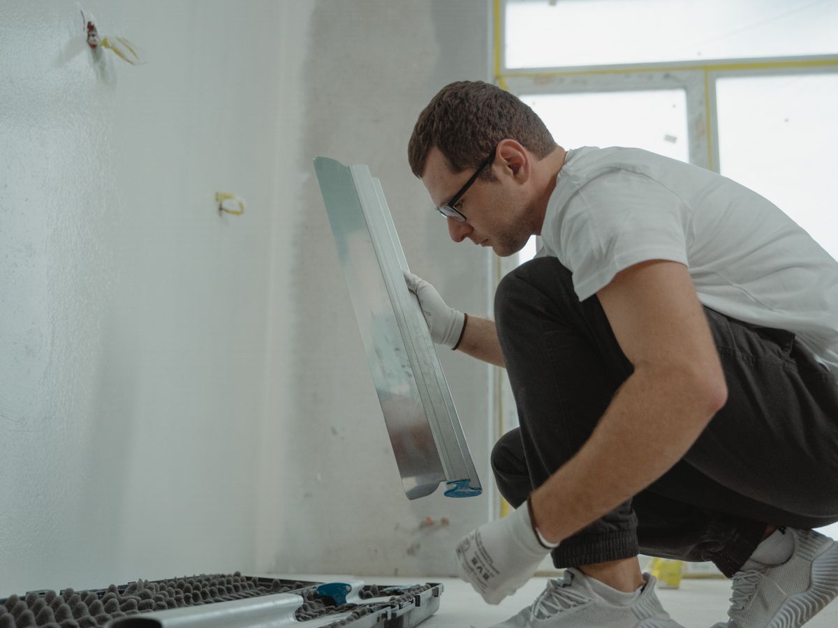 Operario de la empresa alisando una pared con la llana