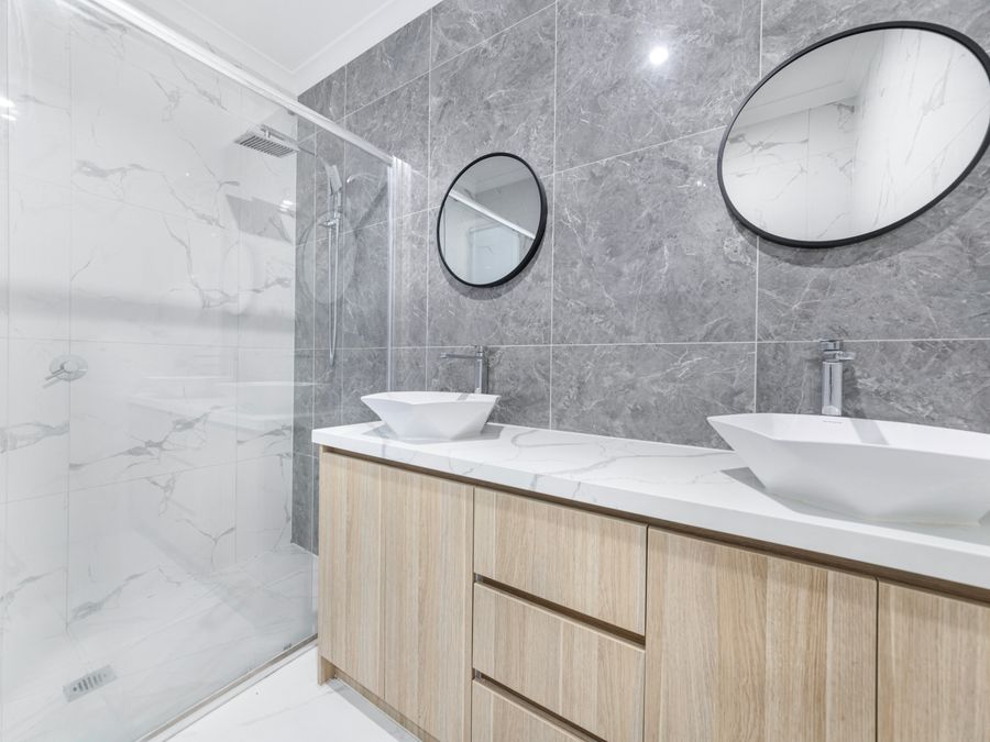 Baño reformado con ducha de obra, mueble de doble seno y espejos